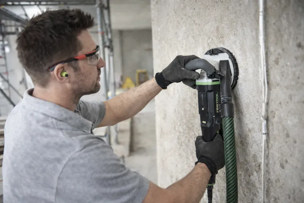 mężczyzna szlifujący beton szlifierką